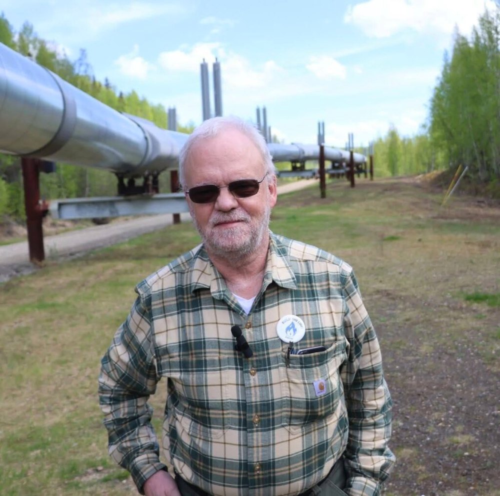 Mike Prax standing beside the Trans-Alaska Pipeline near Fairbanks.